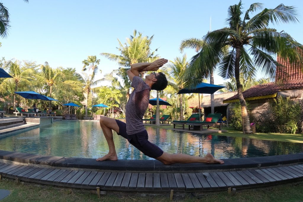 stephen doing yoga beside a pool in bali